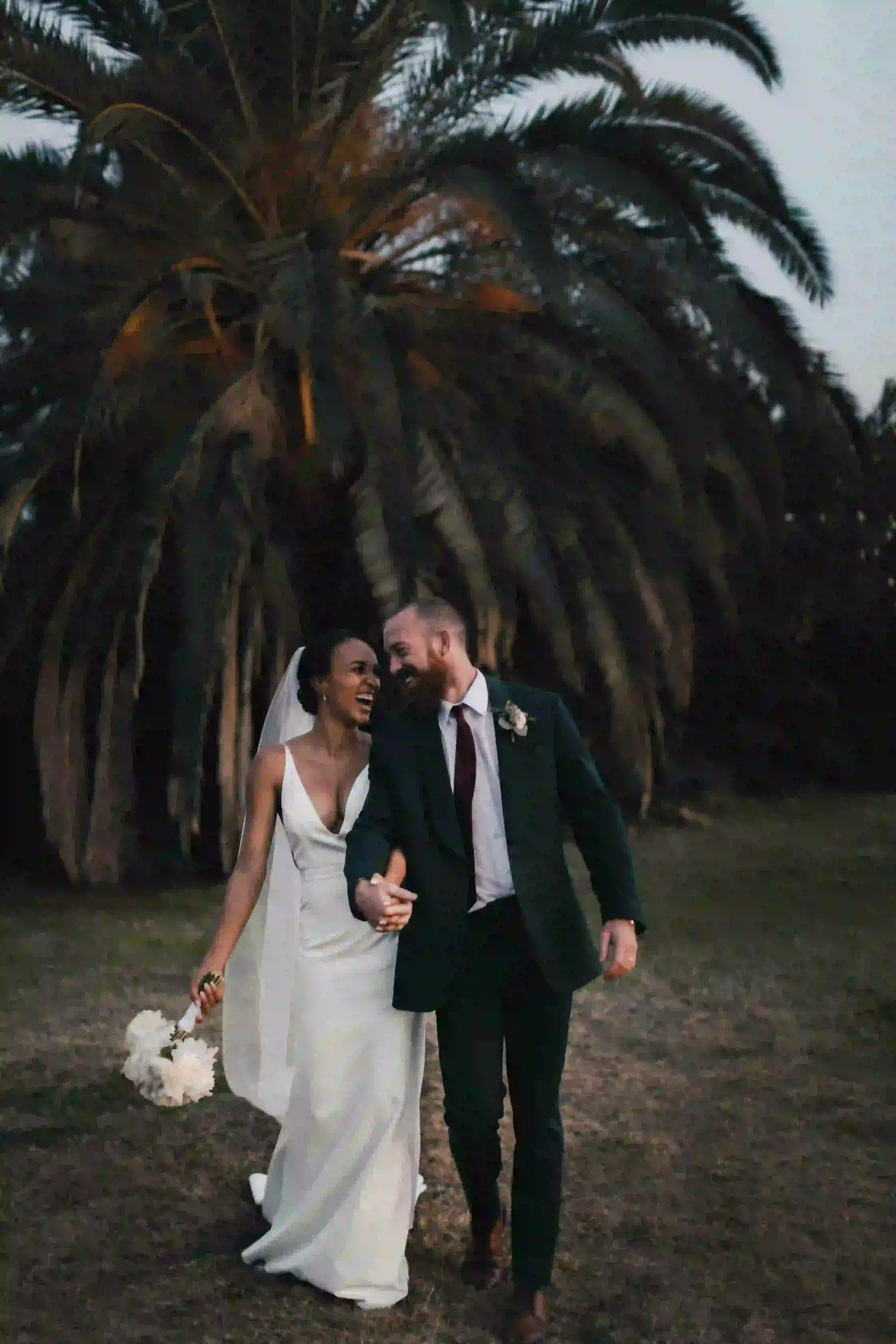 Photographie d'un couple marié devant un palmier